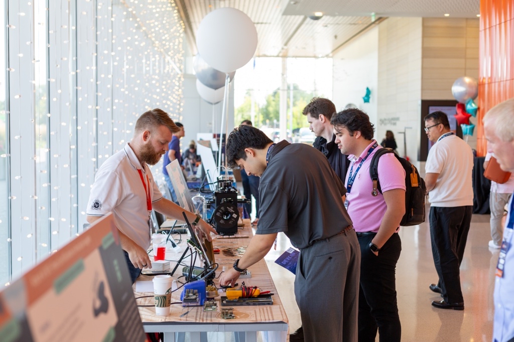 Alex standing at a booth at Devcon 2024 in Milwaukee Wisconsin